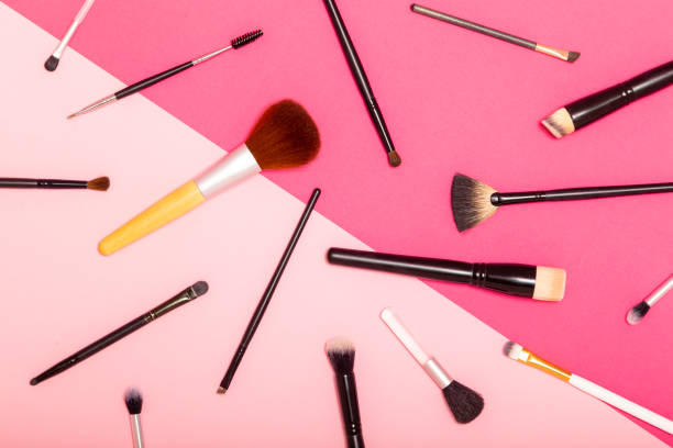 Flat lay of professional make up brushes set isolated on pink background